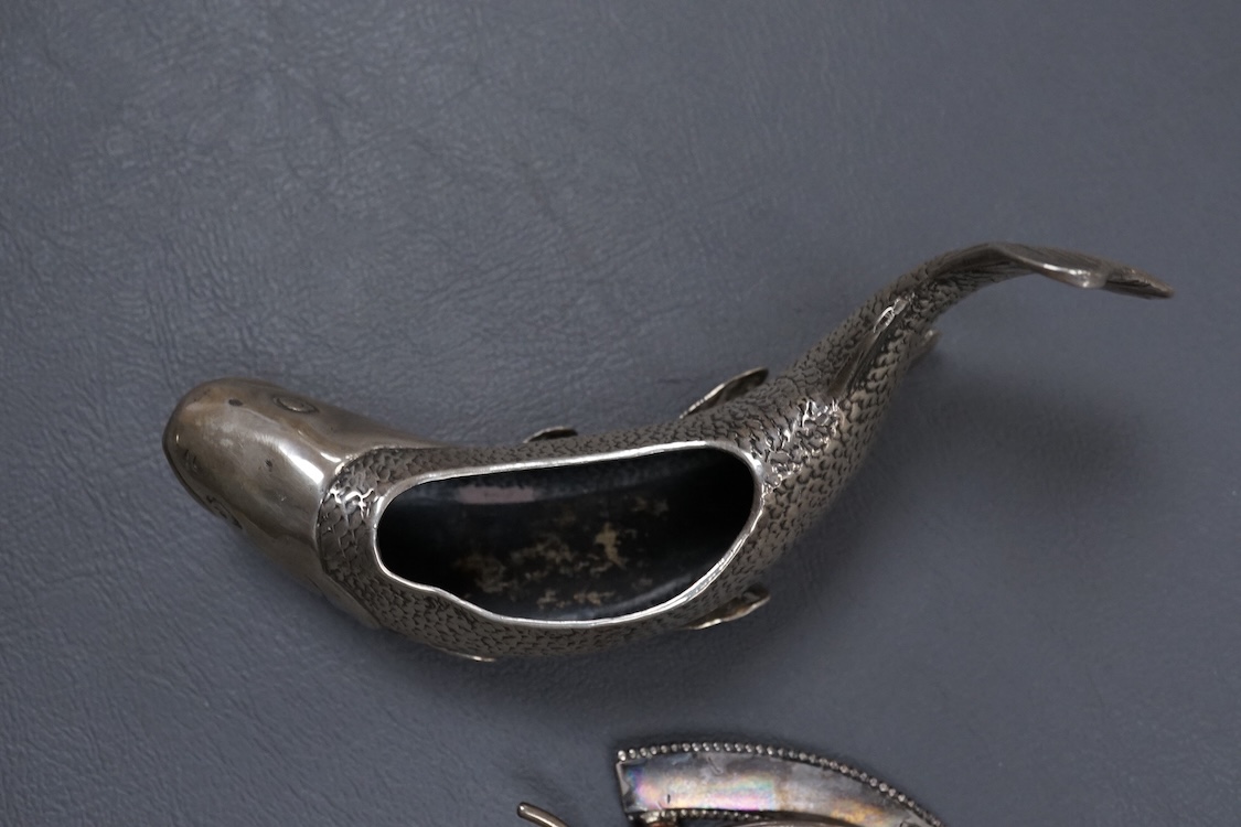 A late Victorian novelty silver and enamelled small photograph frame, modelled as a horseshoe, Birmingham, 1895, height 69mm together with a late 19th century Hanau white metal fish pin cushion(lacking cushion).